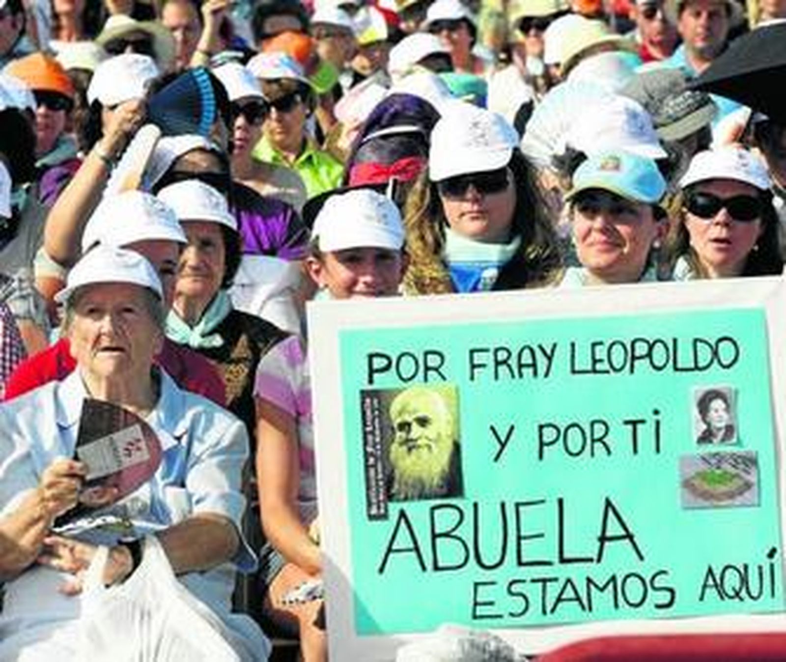 Asistentes al acto de beatificación, con una pancarta alusiva al fraile y a un familiar.