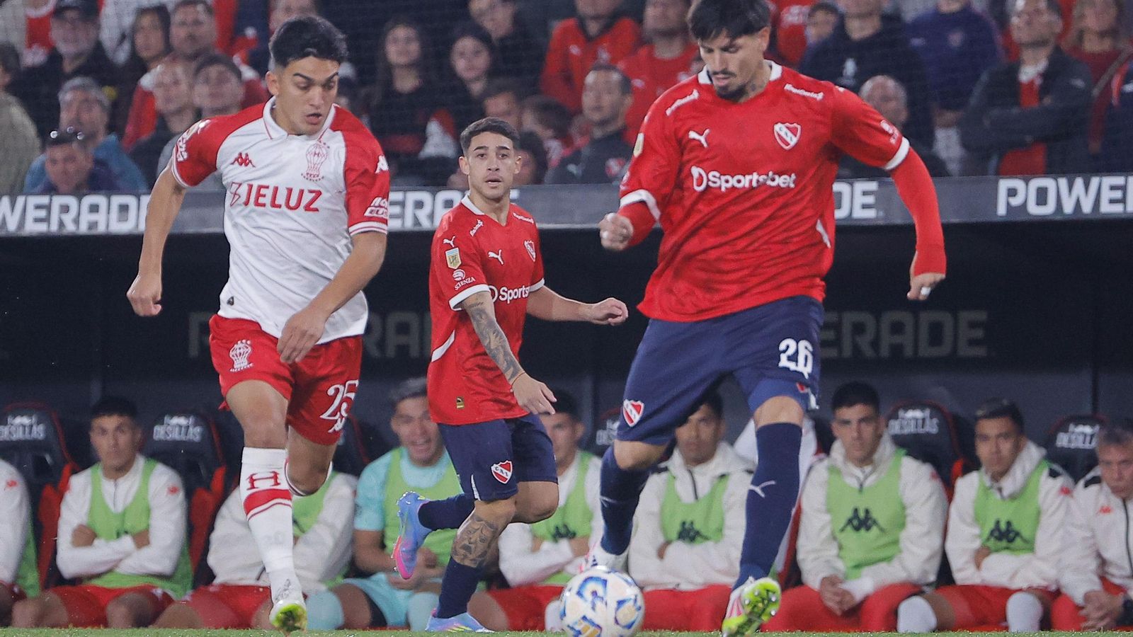 Kevin  Lomónaco es presionado por César Ibáñez, de Huracán, en un encuentro de la liga argentina.