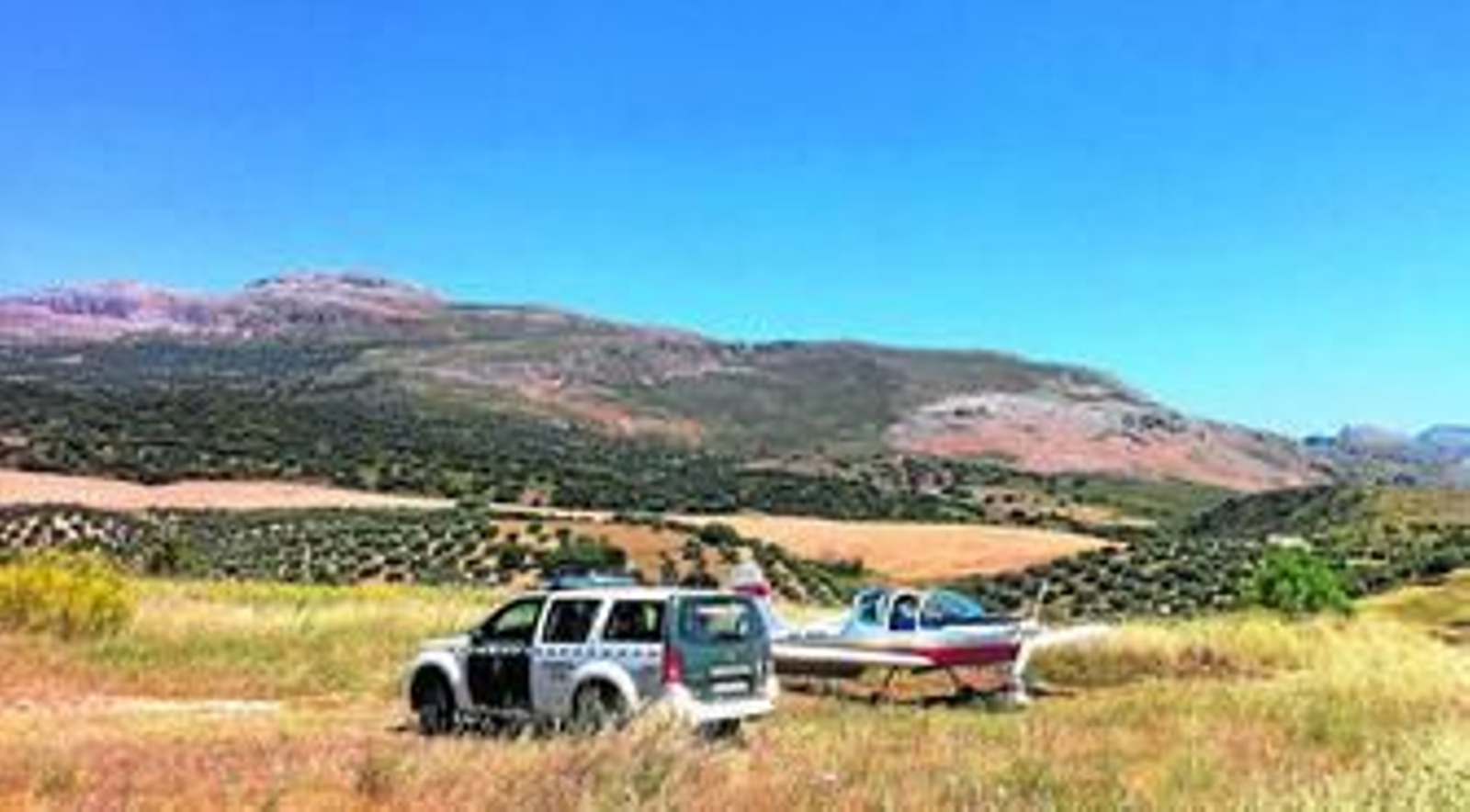 La avioneta que fue obligada a aterrizar en una pista forestal de Ronda custodiada el miércoles por la Guardia Civil.