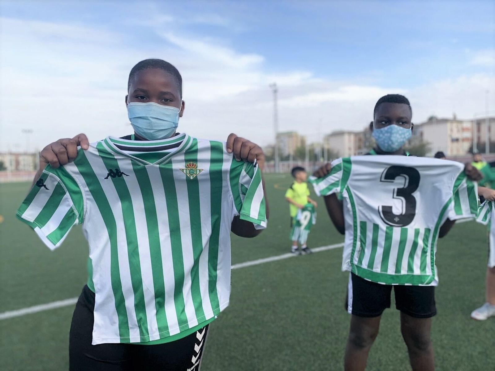 Dos niños posan con las camisetas del Betis.