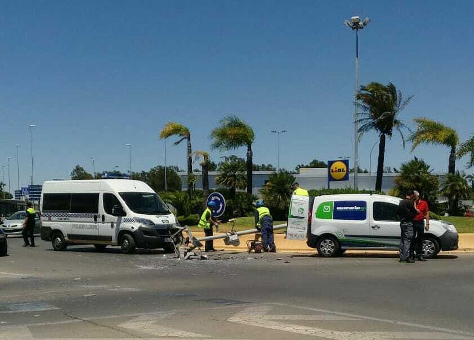 Operarios durante la retirada de la farola en la rotonda junto al Mercadona de los Gallos.