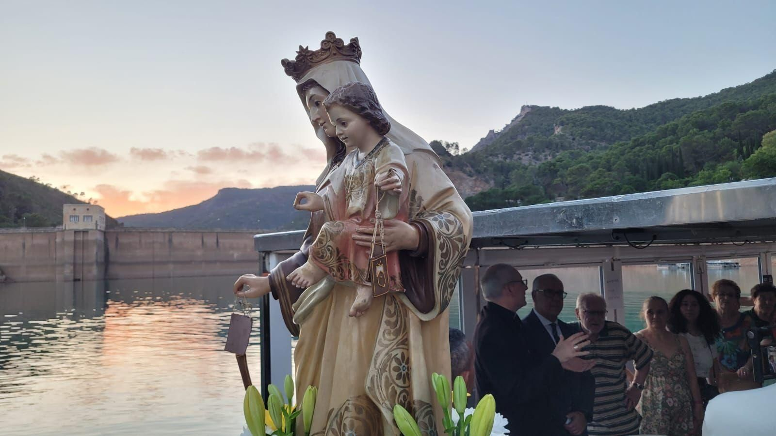 La Virgen del Carmen procesiona sobre las aguas del pantano.