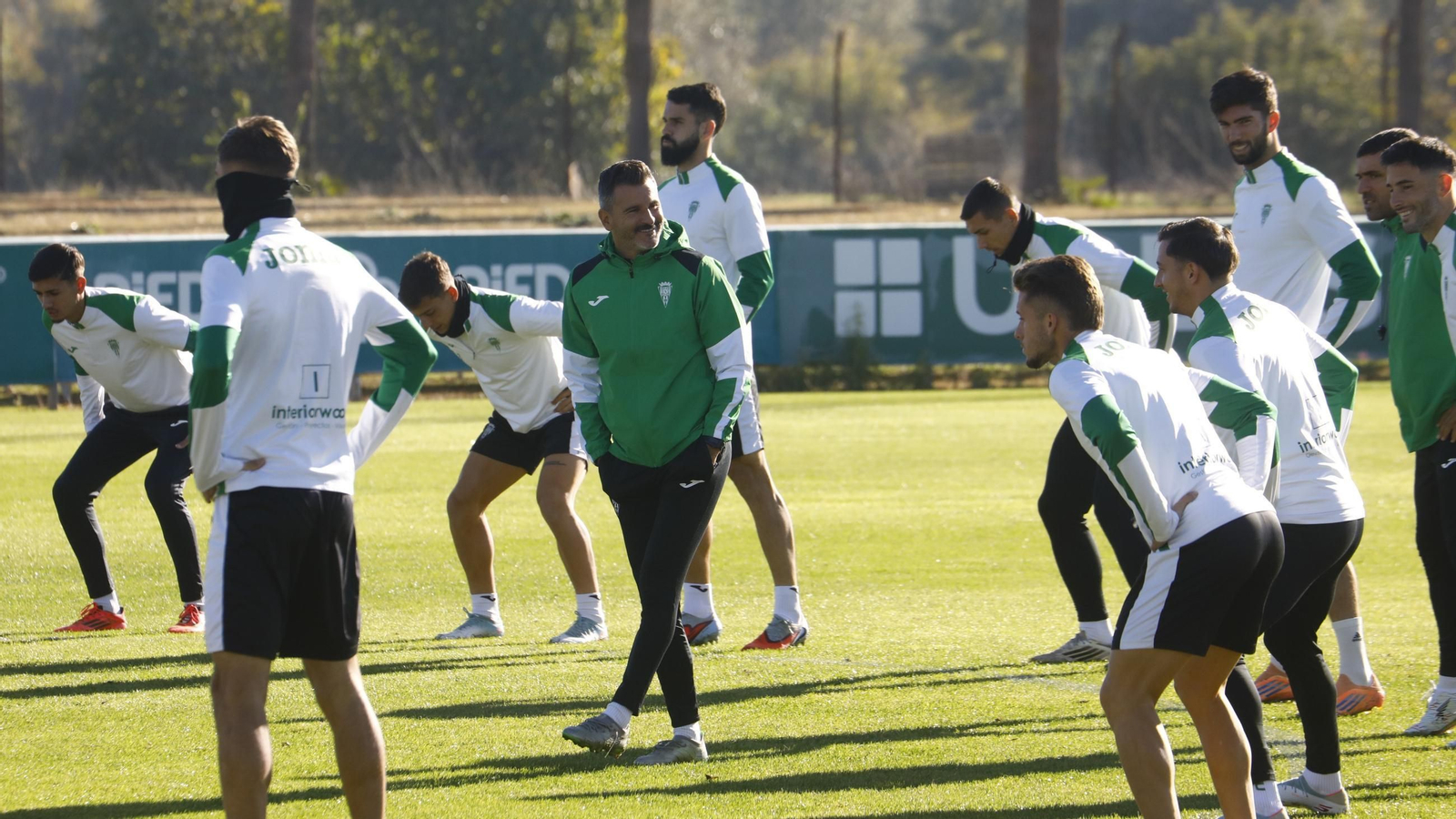 Iván Ania bromea con sus jugadores en el inicio de un entrenamiento del Córdoba CF.