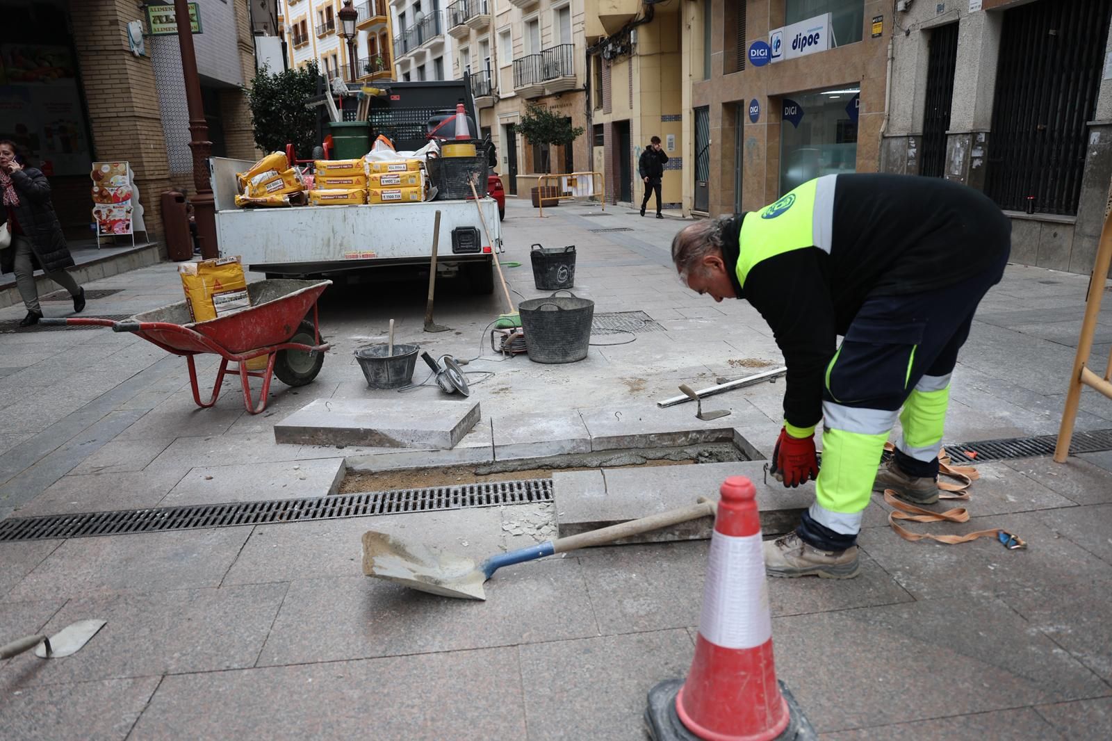 Operario repara pieza levantada en el pavimento. jpg