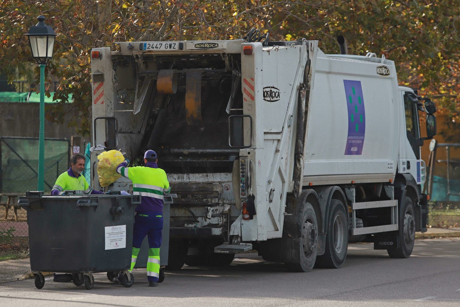 Dos trabajadores de Arcgisa recogen la basura en Los Barrios.