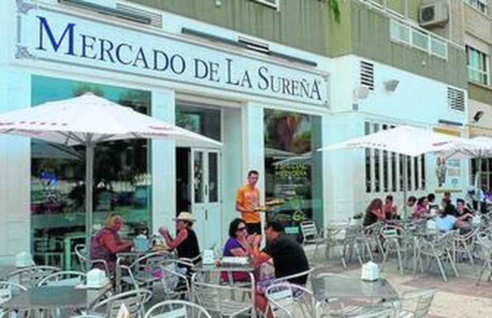 Un grupo de personas disfrutan comiendo en la nueva terraza del Mercado de la Sureña en Huelin.
