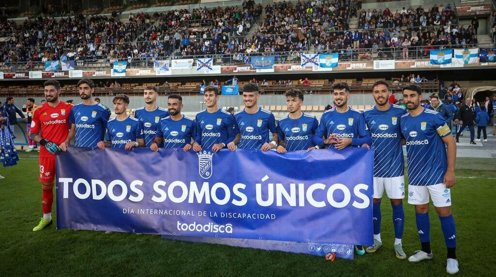 El Xerez CD volvió a ganar ante el colista Coria y posa con una pancarta dedicada al día de la discapacidad.