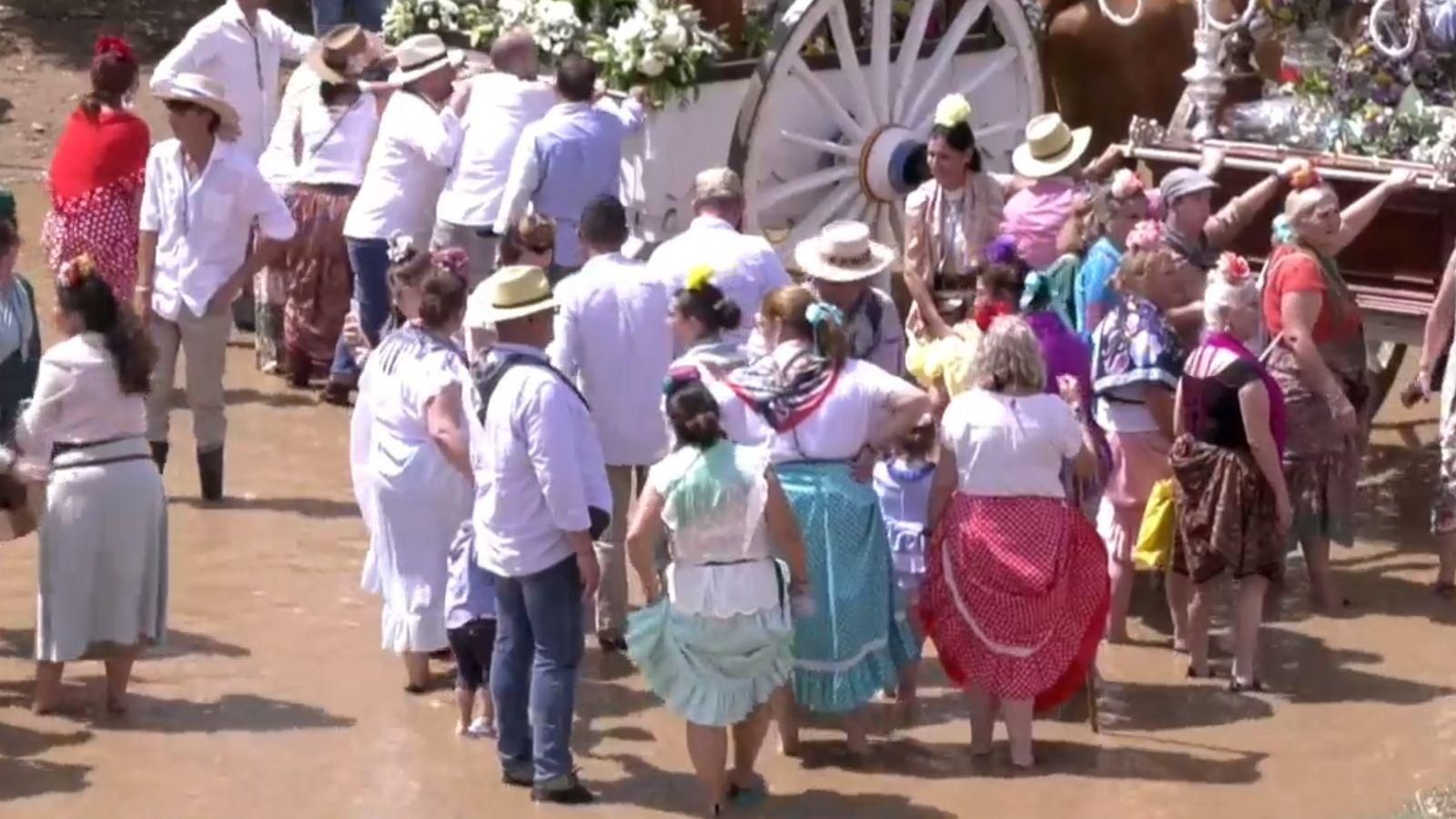Rocieras con las batas levantadas para cruzar el Guadiamar.