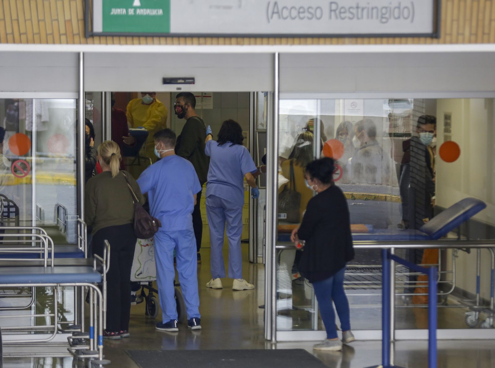 Varias personas y algunos sanitarios en uno de los accesos a las Urgencias del Virgen del Rocío.