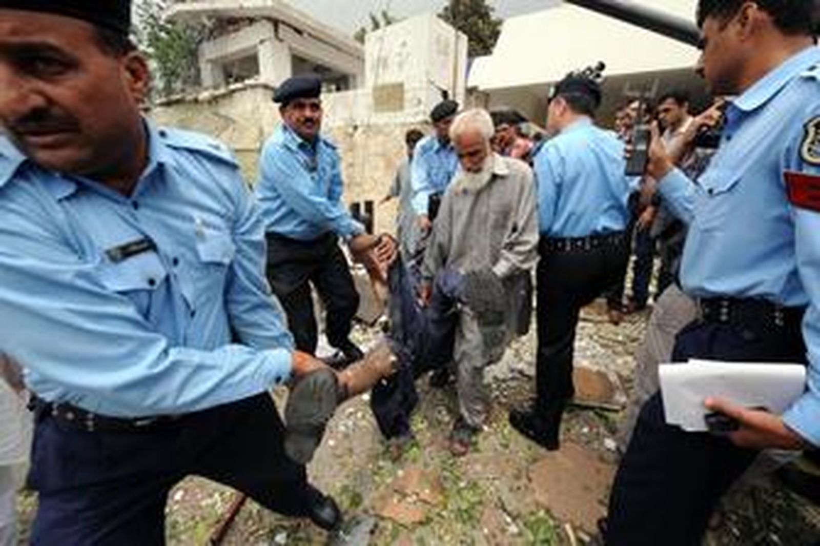 Polícías paquistaníes sacan un cuerpo de la Embajada danesa en Islamabad, ayer.