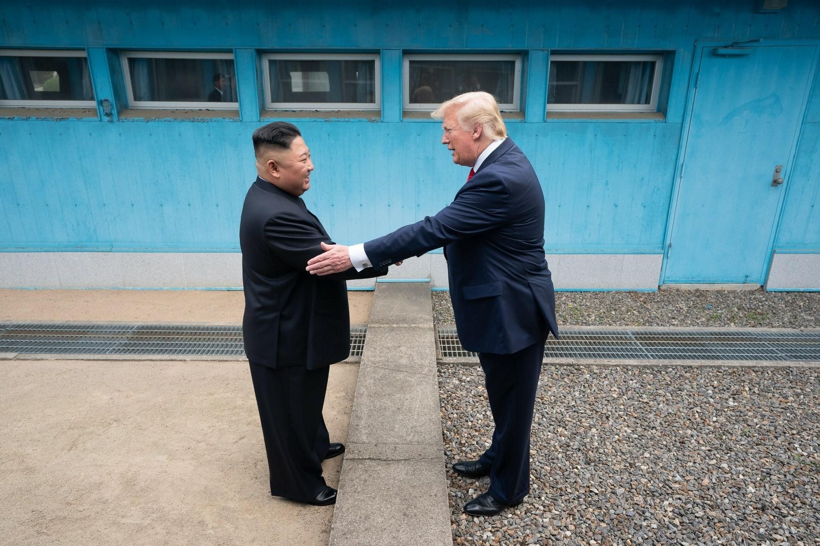 Kim Jong-un y Donald Trump se saludan en la zona desmilitarizada.