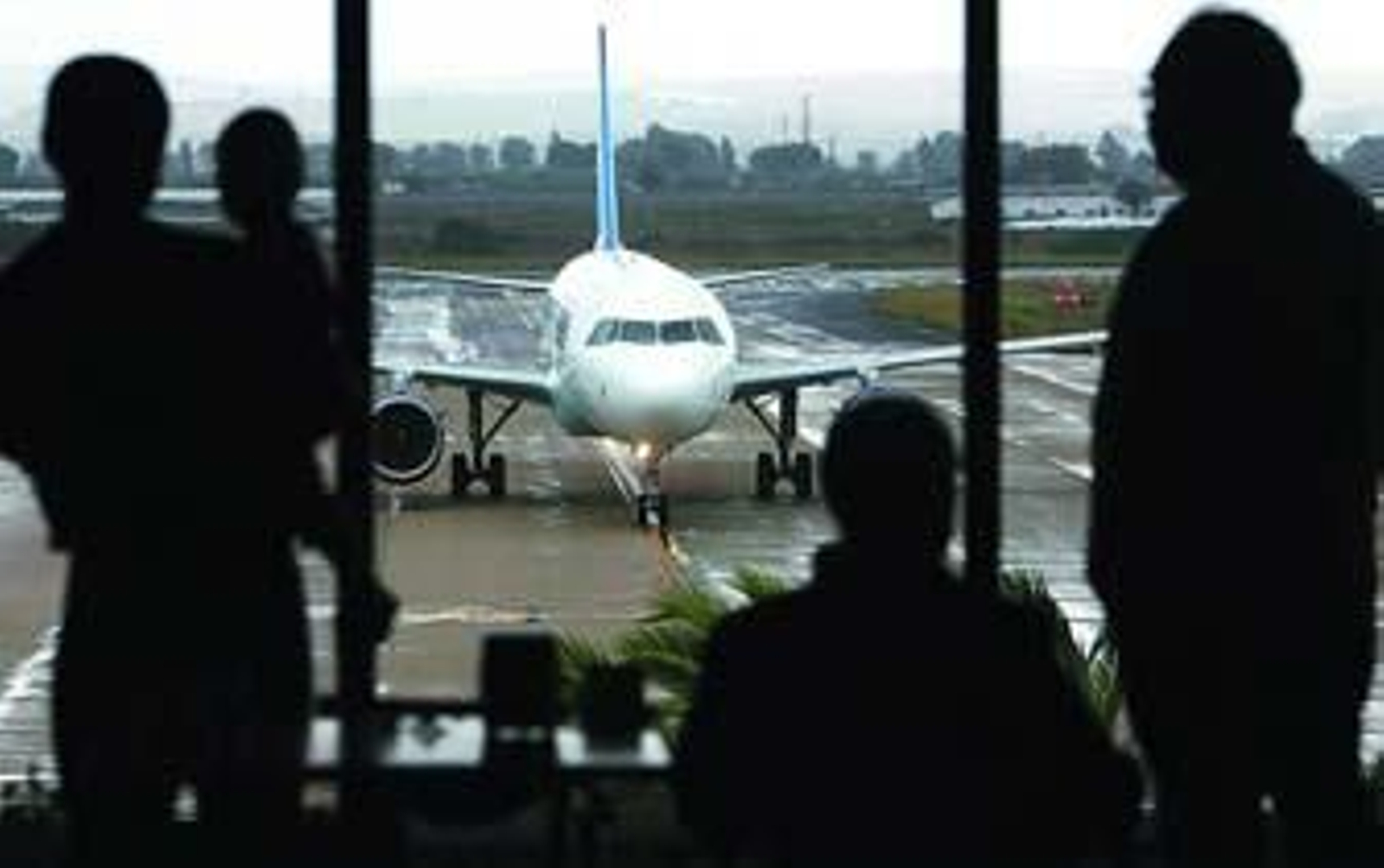 Varias personas observan un avión de Ryanair desde la cafetería del aeropuerto de Jerez./Miguel Ángel González