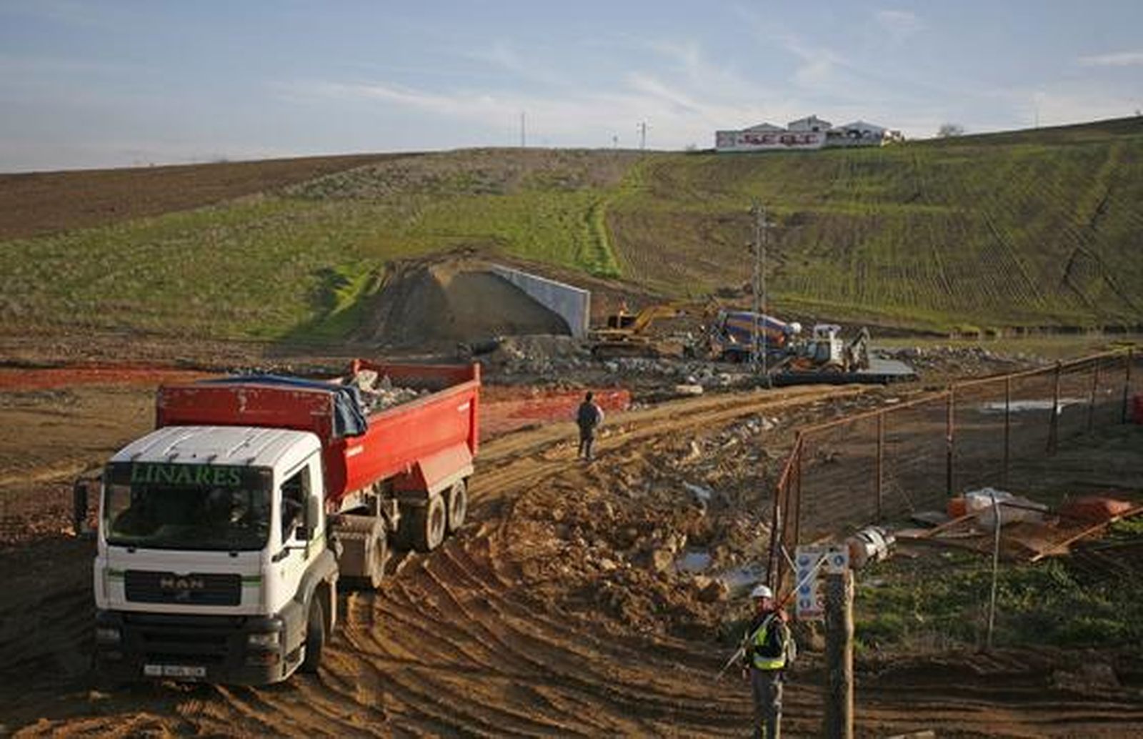 Los trabajadores construyen el nuevo dique colocando las 37 toneladas de piedra de escollera, transportadas por el camión, para evitar que la abundante agua del arroyo inunde Écija de nuevo.

Foto: Antonio Pizarro