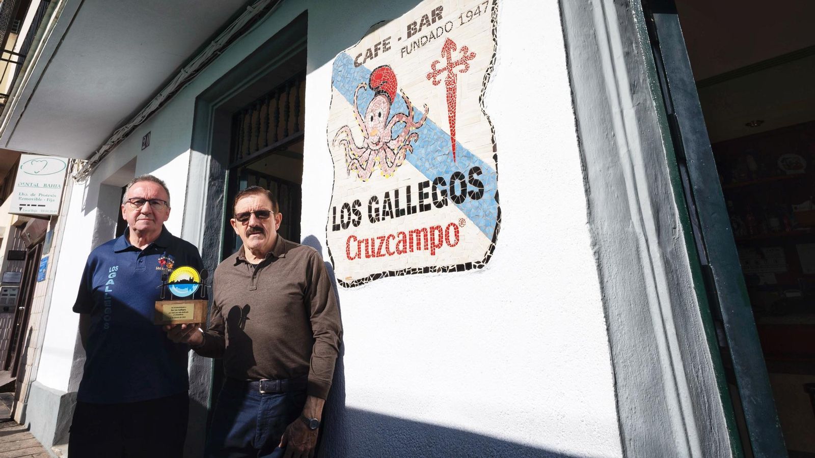 Los hermanos Sixto, en la fachada de su negocio con el reconocimeinto que esta semana les entregó Asihtur.