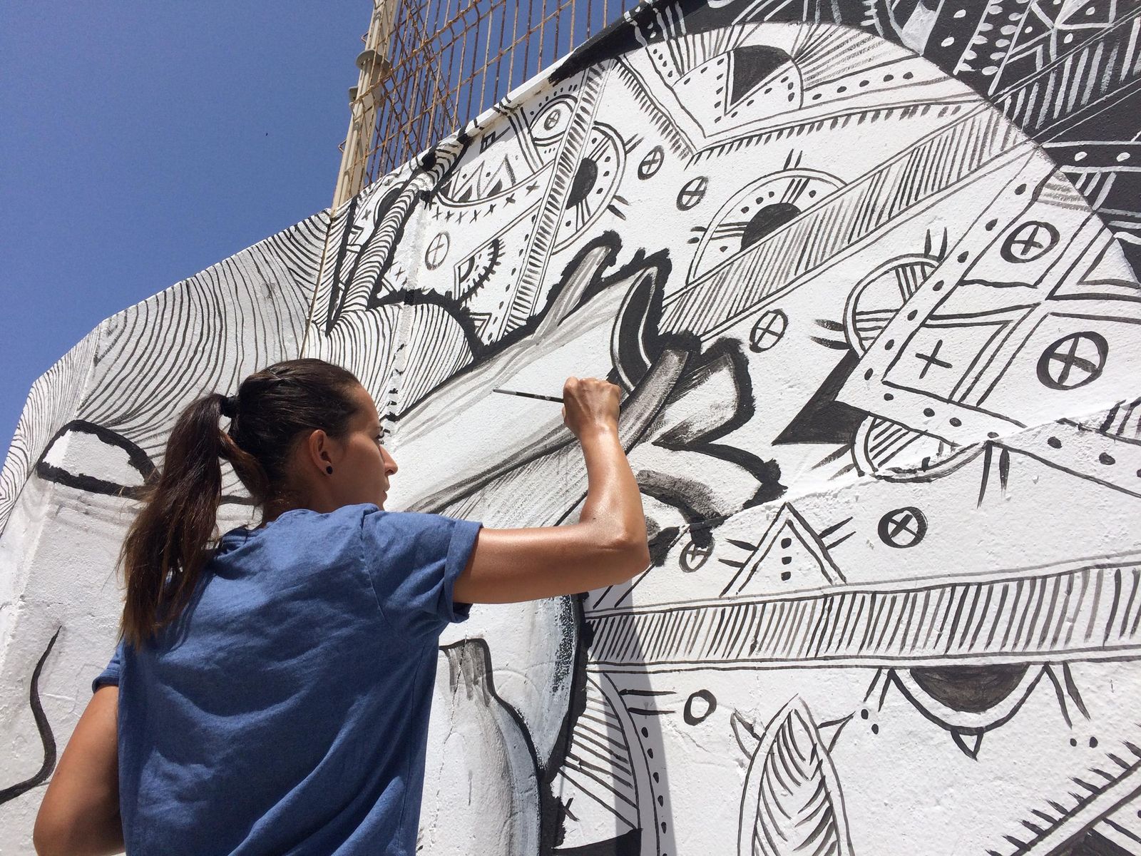 Laura Pintado retoca uno de los motivos de la composición que quedará en el muro del Almadraba.