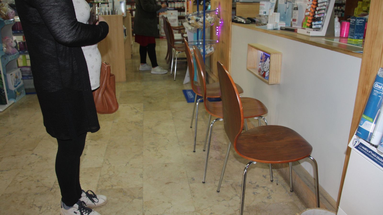 Unas sillas como barrera en el interior de una farmacia.