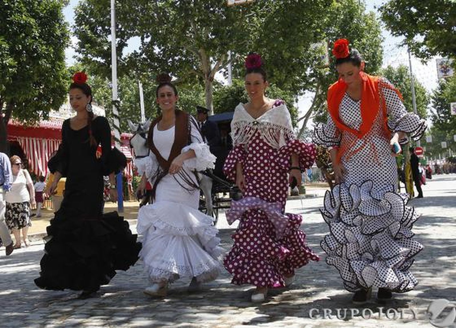 Varias chicas en el Real vestidas de flamenca.

Foto: José Ángel García
