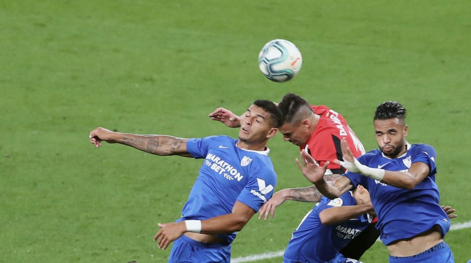 Diego Carlos y En-Nesyri salta con Dani García en un balón aéreo.