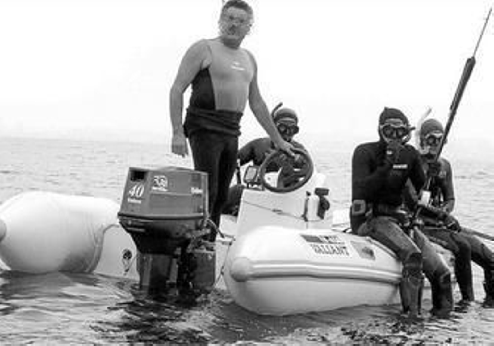Varias personas practican la pesca submarina en alta mar.