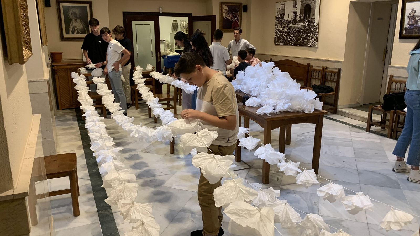 El grupo joven preparando las guirnaldas de papel para la procesión
