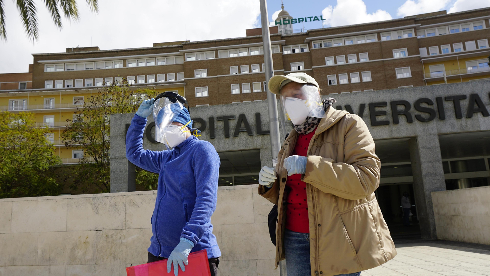 Dos personas protegidas con EPI a la salida de un hospital.