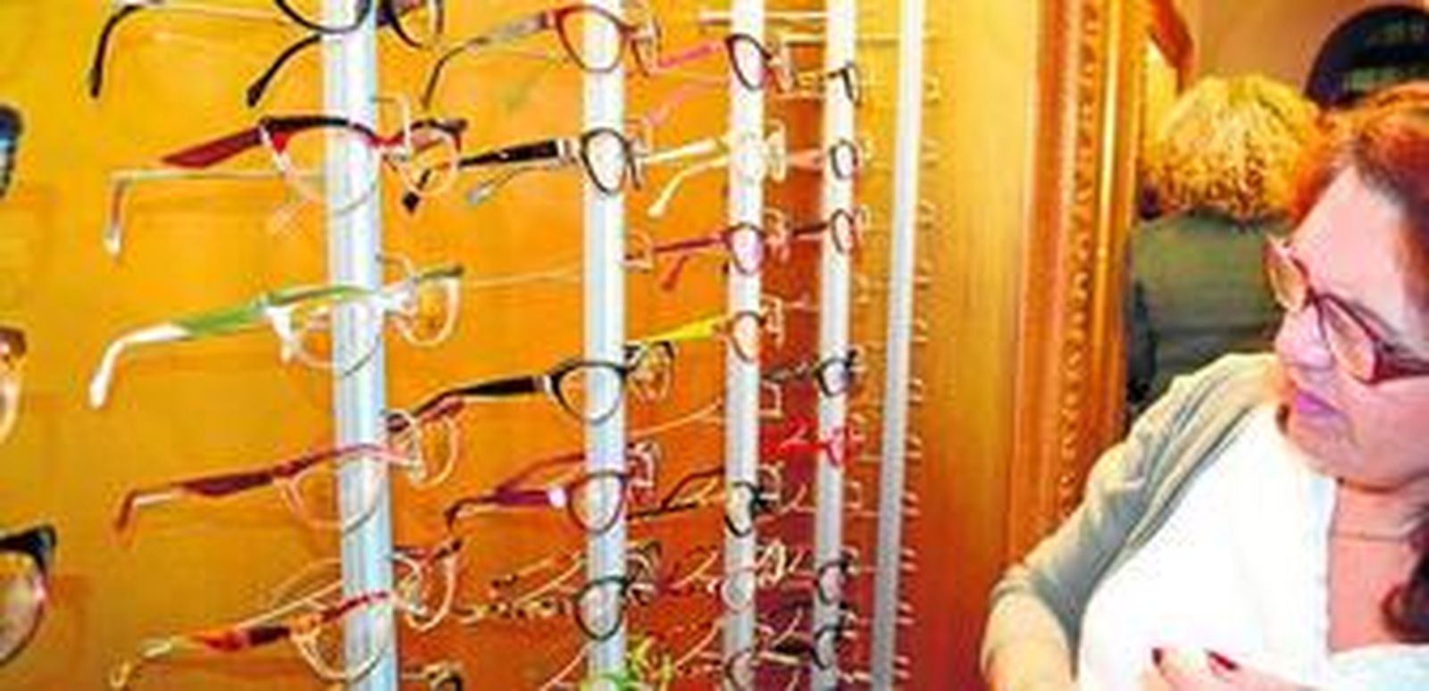 Una señora busca unas gafas de aumento en un establecimiento.