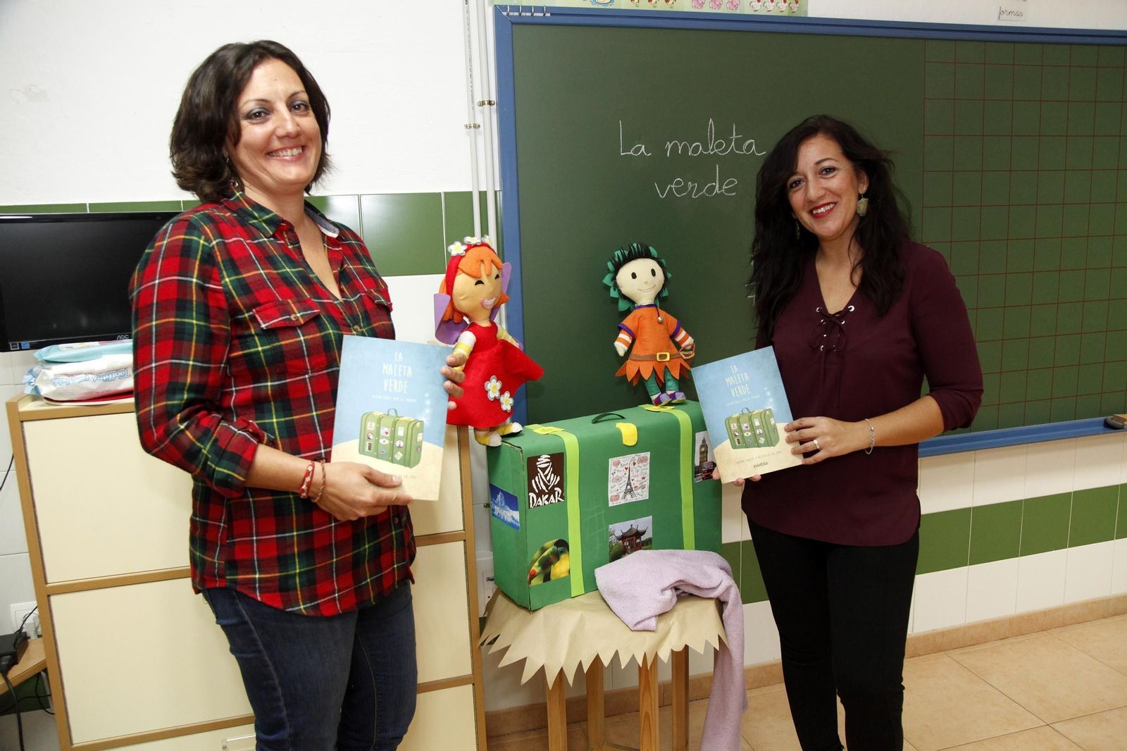 Las autoras de 'La maleta verde' posan con ejemplares del libro en la clase de Infantil.