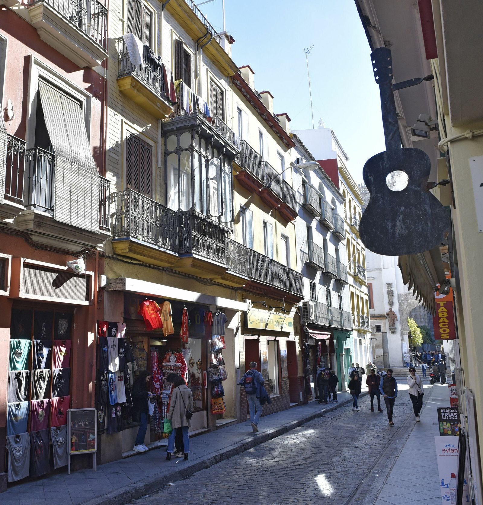 Tres turistas en la puerta de una tienda de recuerdos de la calle Hernando Colón.