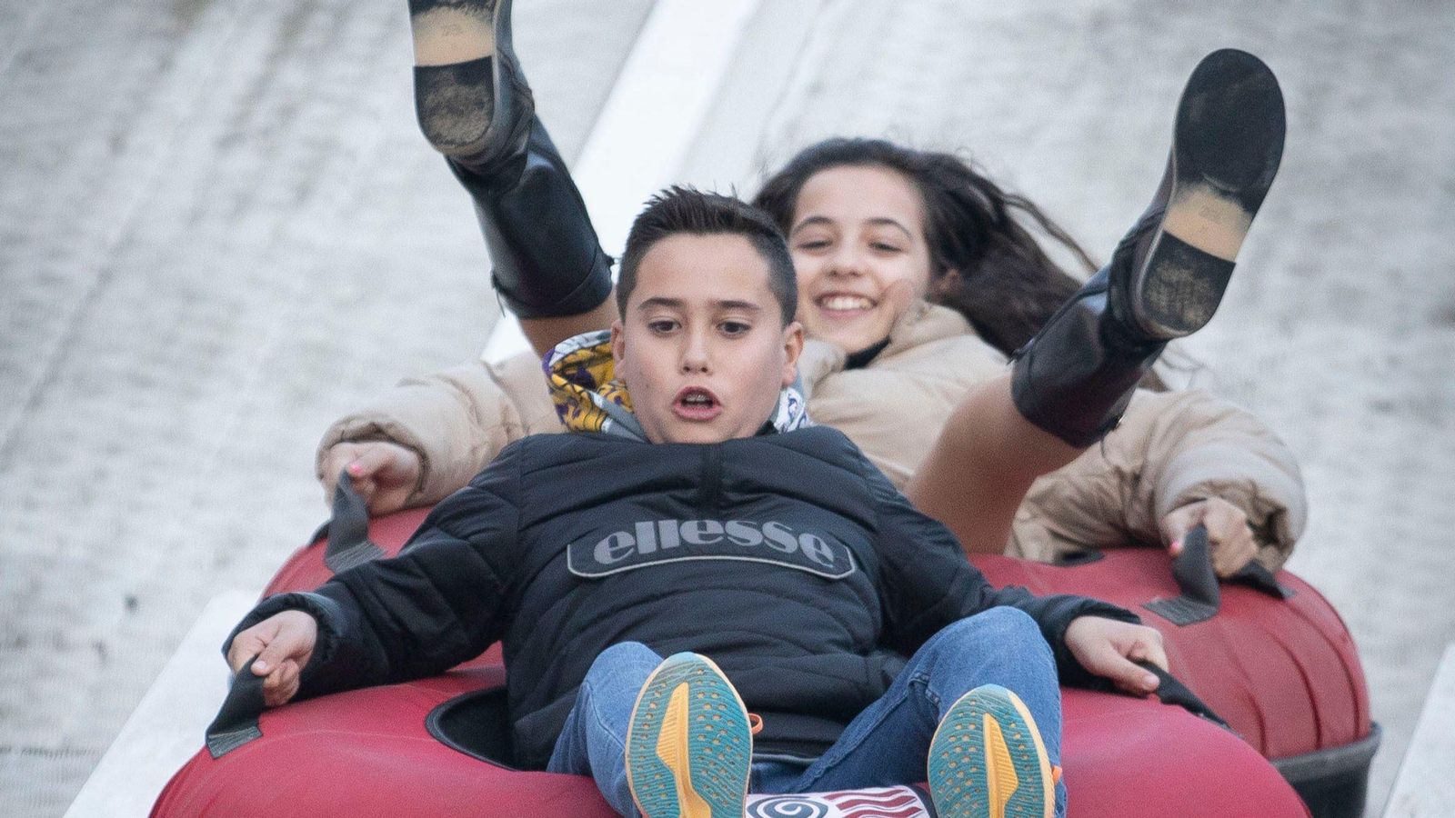 Unos niños descienden con el trineo en Granada