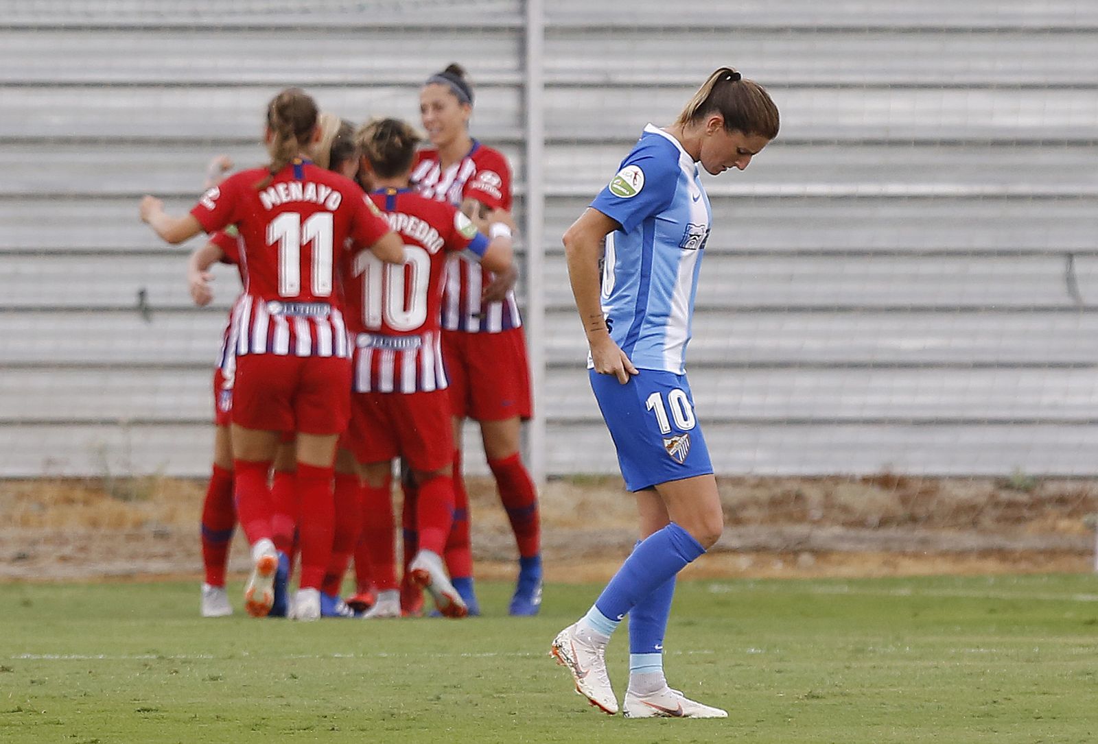 Adriana Martín se lamenta, con las jugadoras del Atlético de Madrid celebrando al fondo.