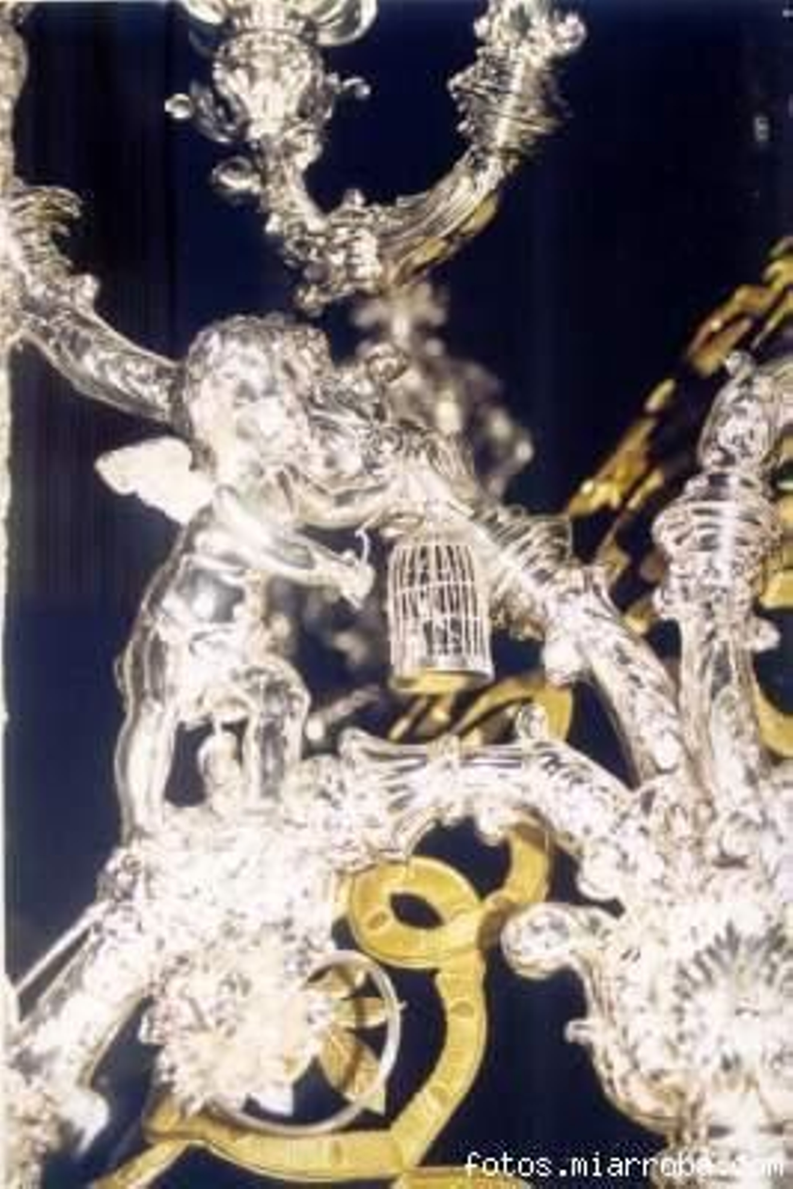 Un angelito encierra en una jaula a un pájaro en el palio del Cerro