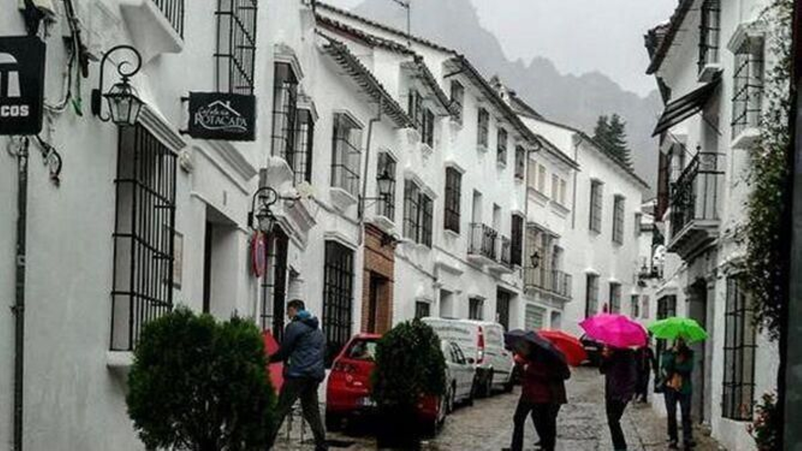 Un grupo de personas pasea por las calles de Grazalema, en un día lluvioso