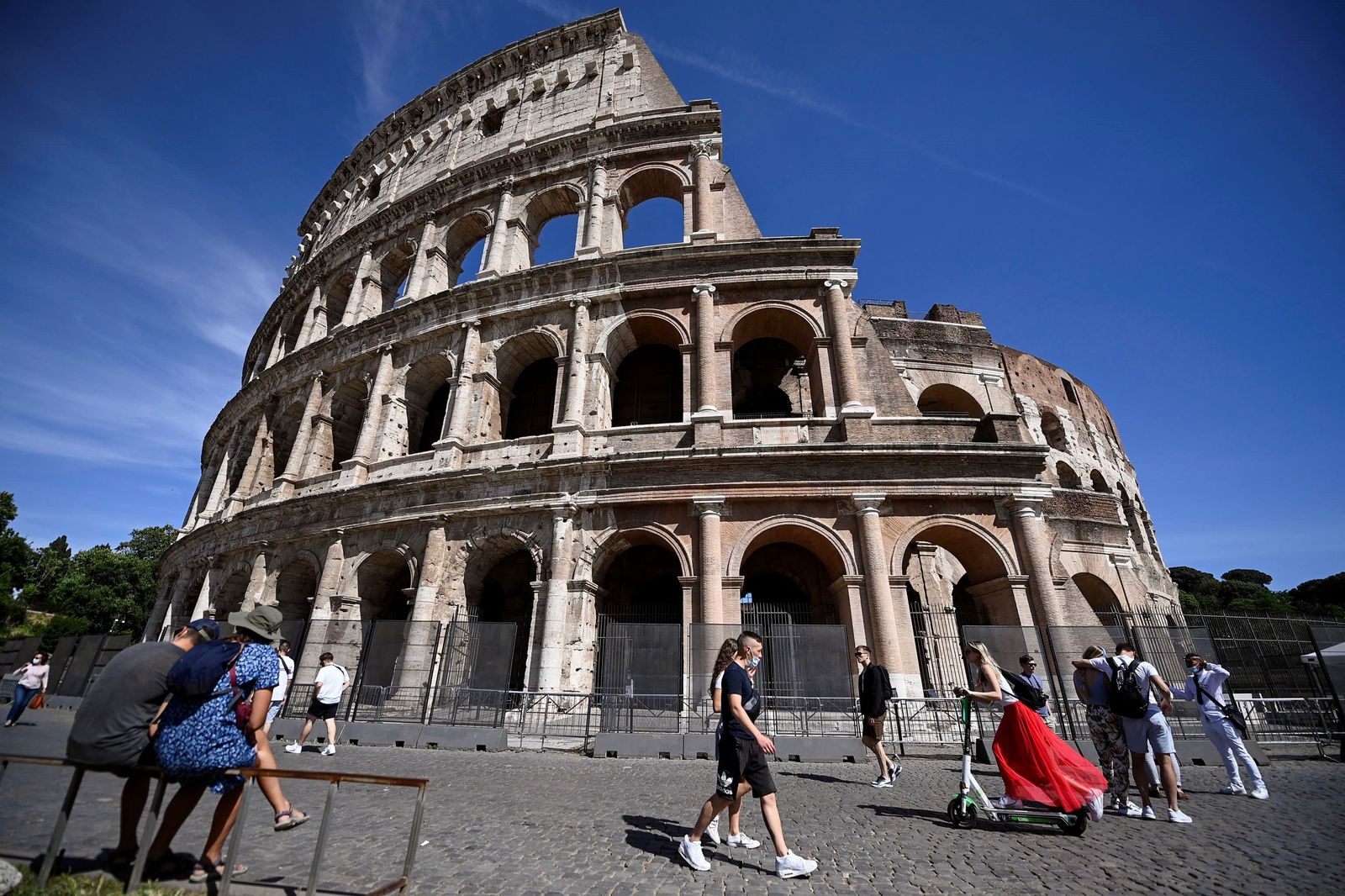Gente paseando con y sin mascarillas por el Coliseo de Roma.