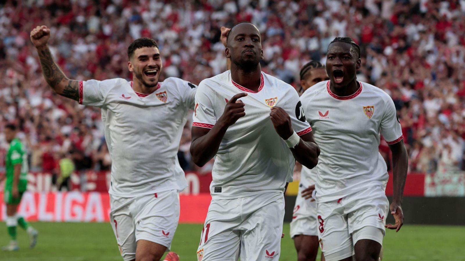 Lukébakio celebra su gol de penalti al Betis junto a Isaac y Agoumé.