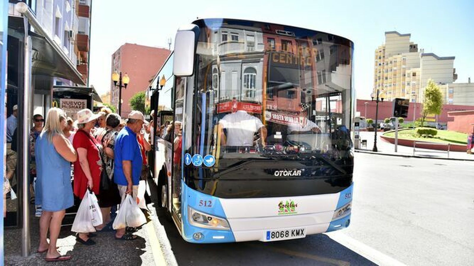 Vecinos de La Línea suben a un bus urbano en una céntrica parada.