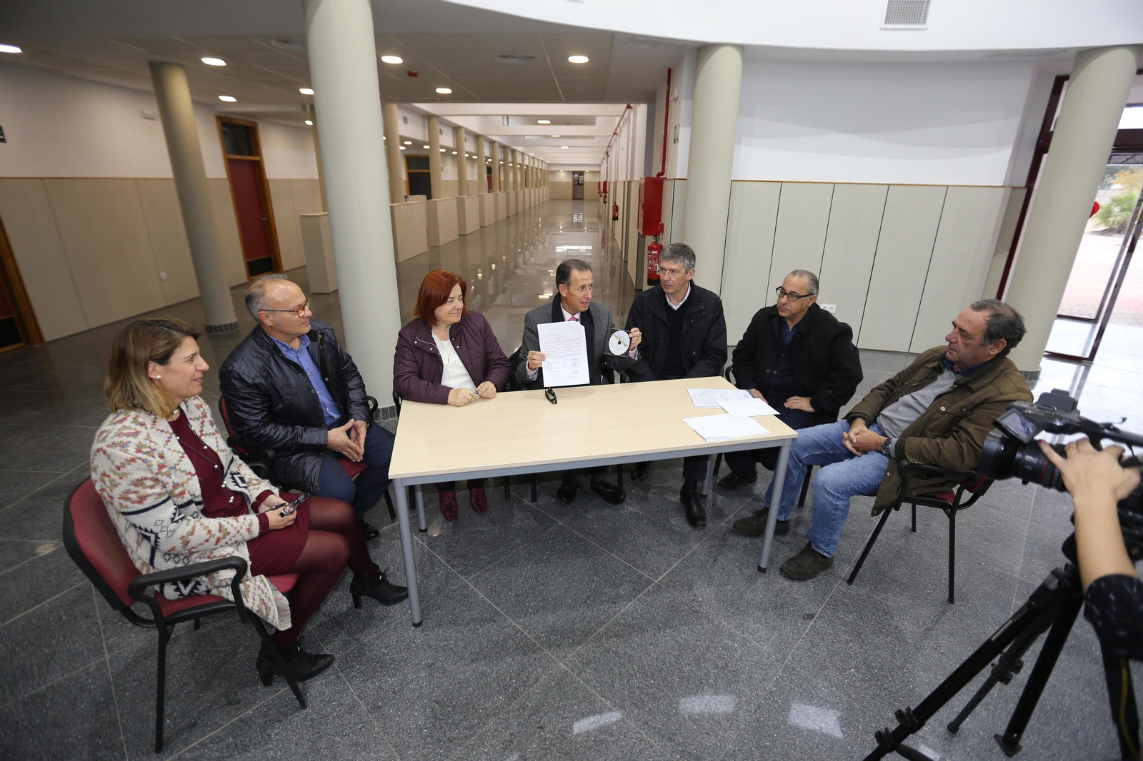 El alcalde muestra el documento de recepción de los trabajos.