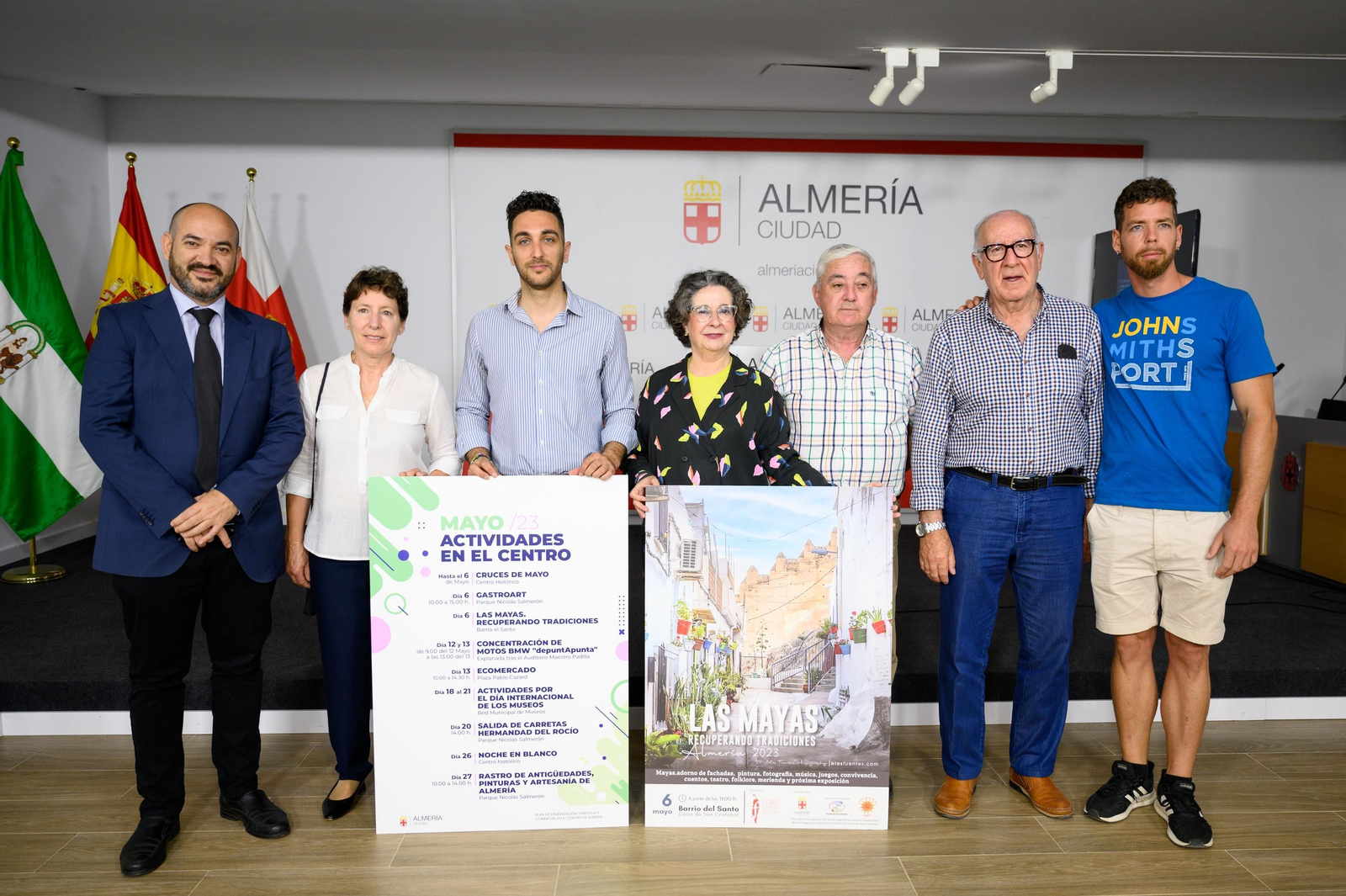 Jesús Luque, en el centro, sostiene el cartel de las actividades en el centro de este mes de mayo