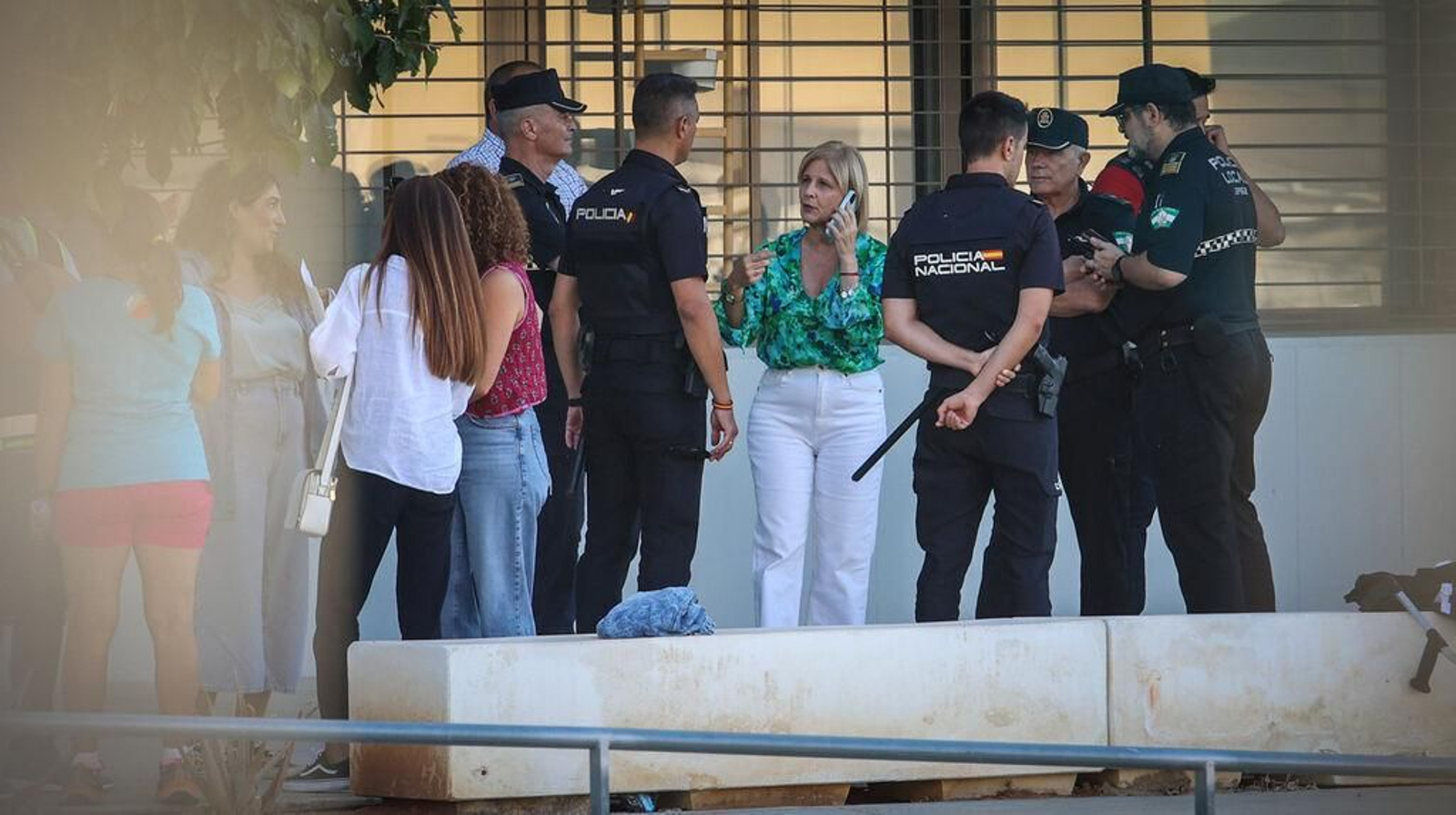 La alcaldesa María José García-Pelayo habla por teléfono y charla con un agente de la Policía Nacional.