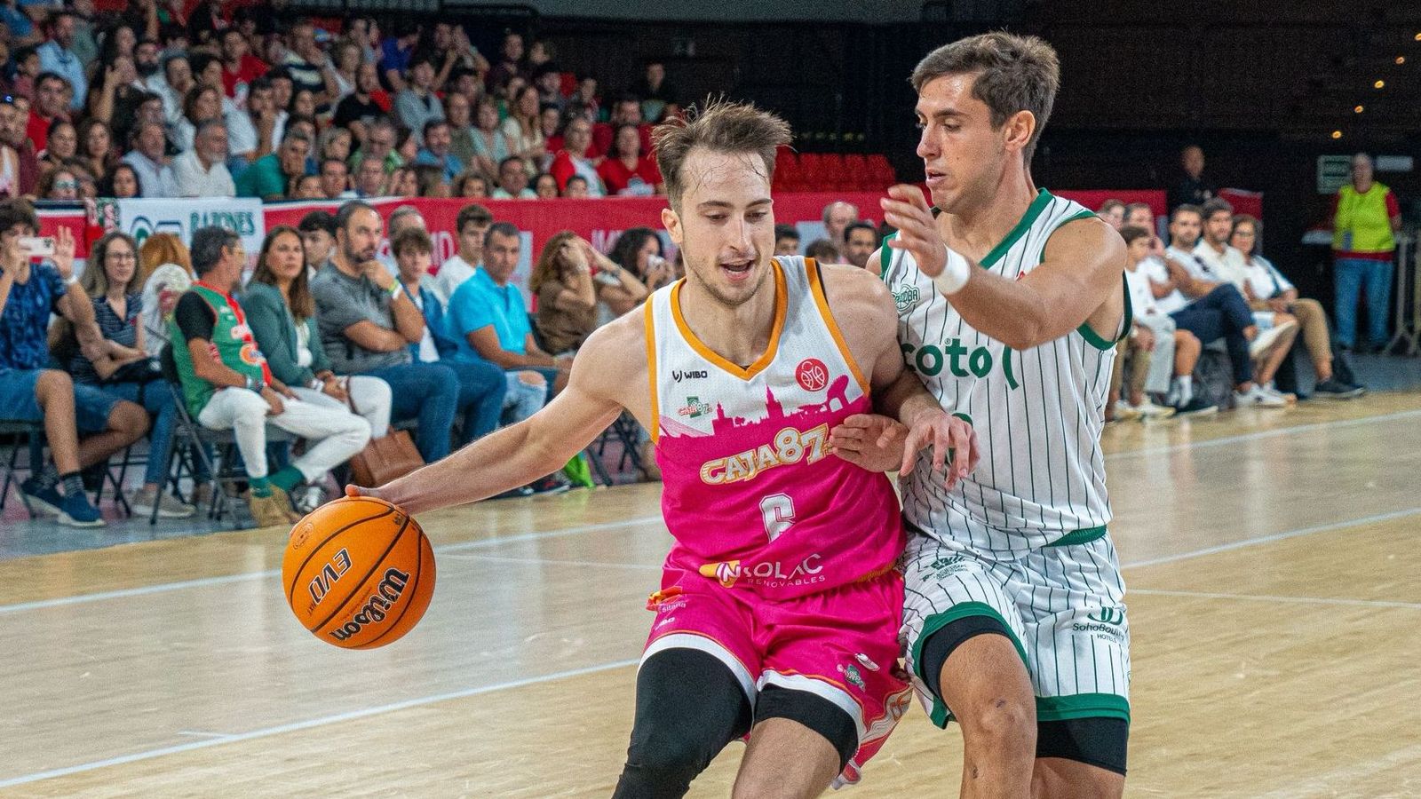 Rafa Santos sube la pelota defendido por un rival.