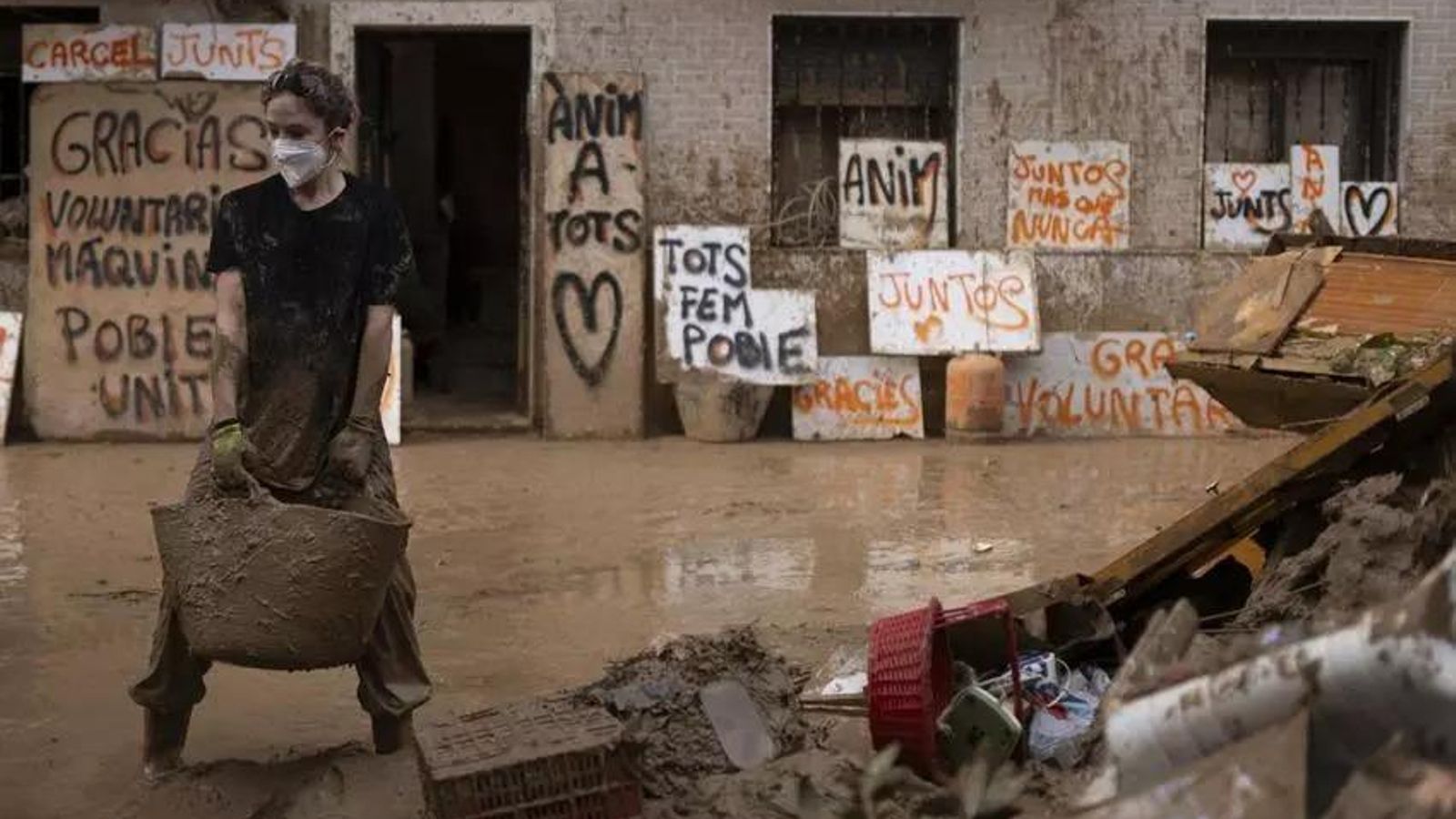 Un voluntario en Valencia con carteles de ánimo detrás.