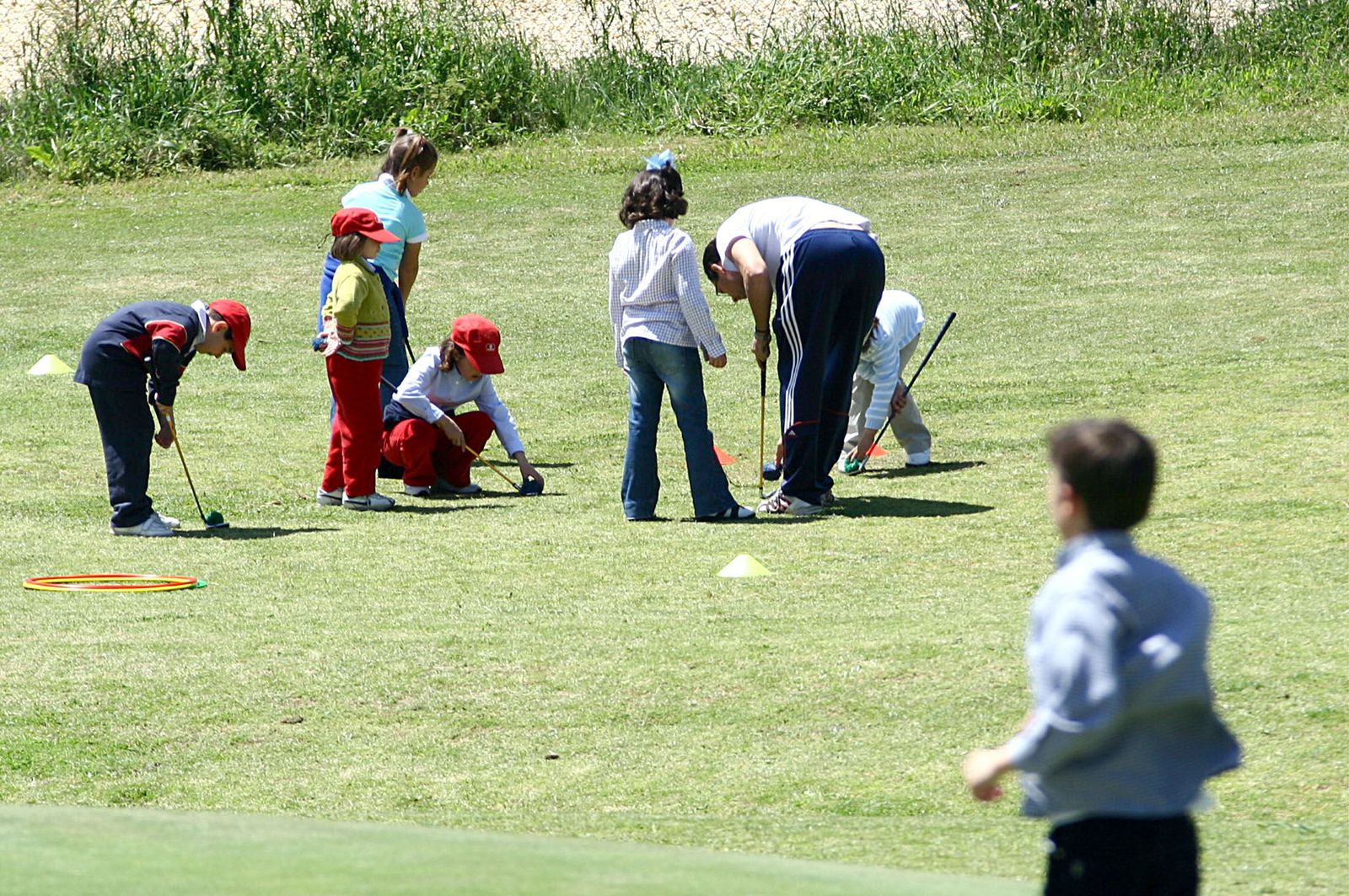 Niños juegan al golf.