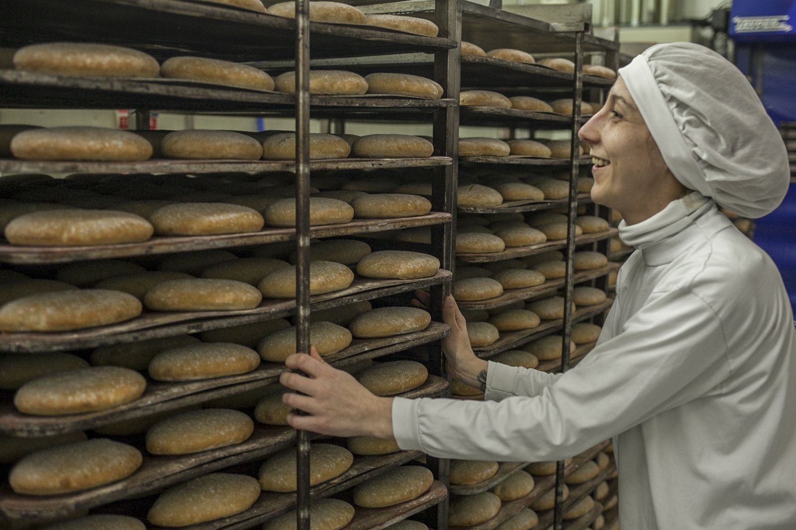Una trabajadora maneja los molletes en el interior del horno.