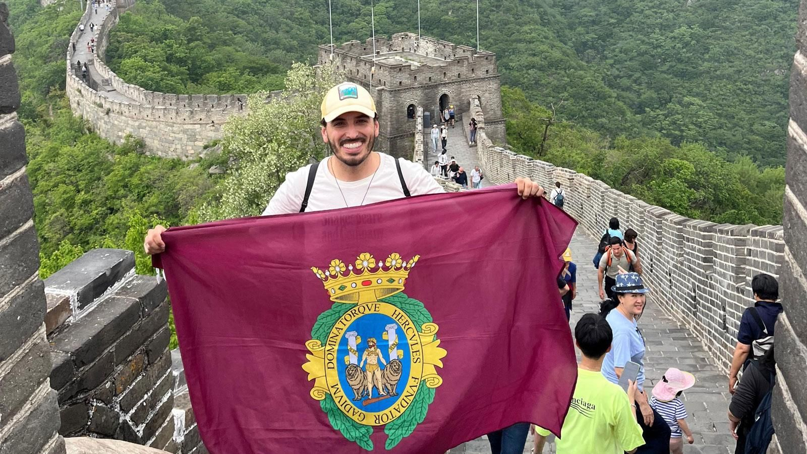 El guía turístico gaditano Jesús Carrillo lleva la bandera de Cádiz hasta la muralla china.