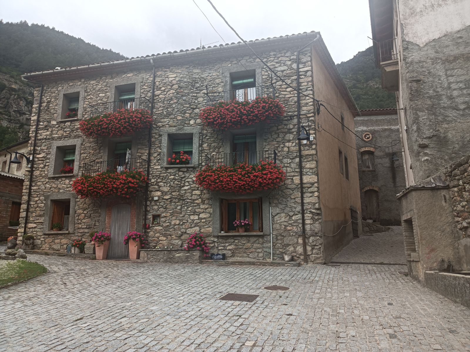 Casa de Forcat. El contraste de la piedra y las coloridas flores llamará nuestra atención.