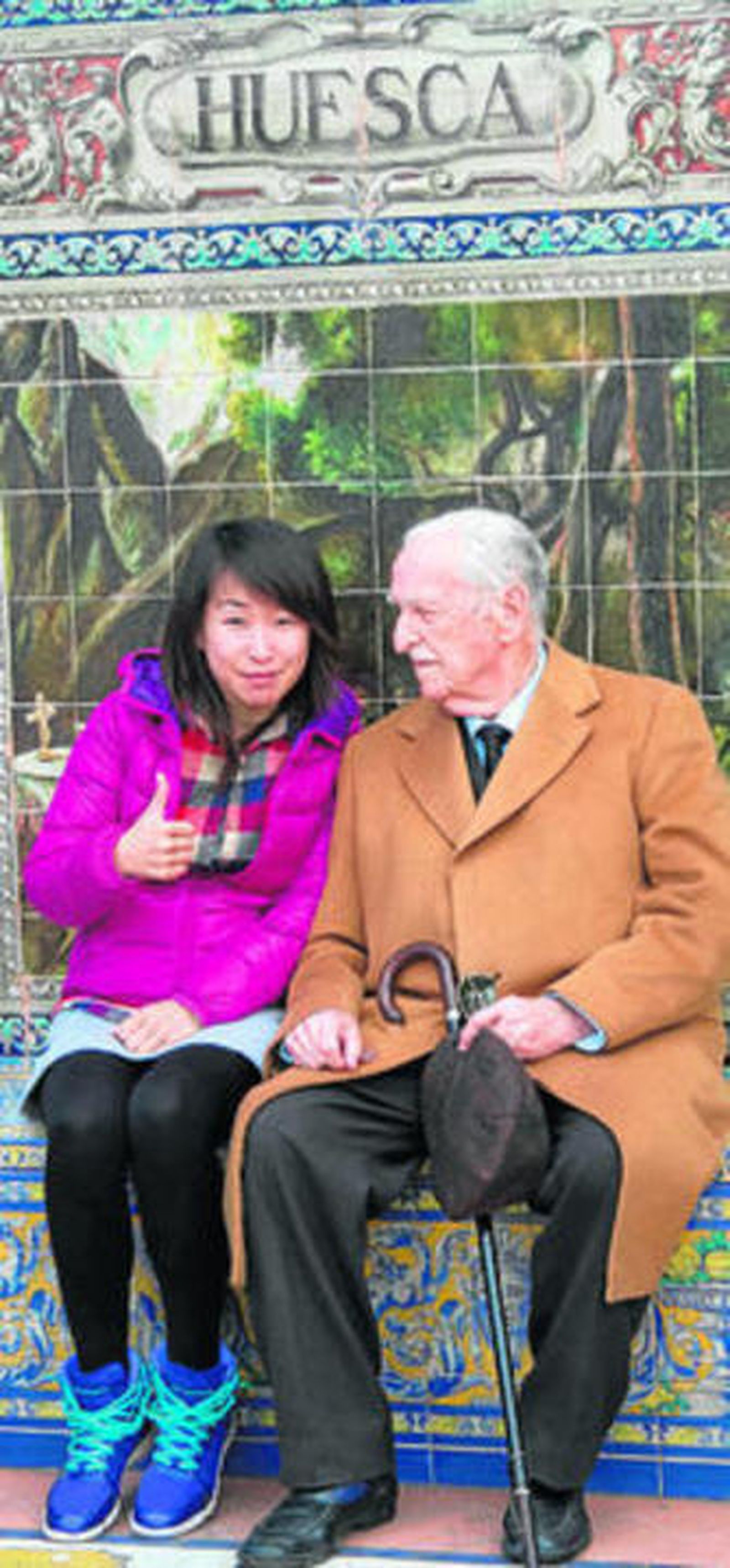 Luis Díaz del Río, con una turista china en el banco de Huesca.