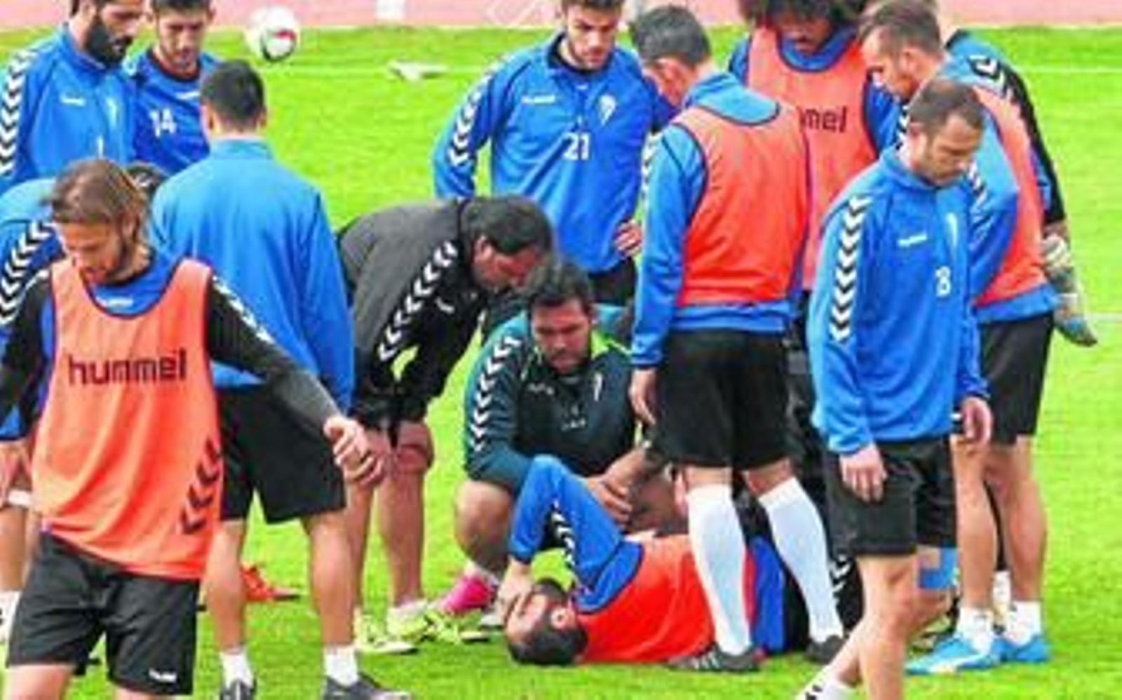 Juanjo, tendido en el césped, se cubre la cara con una mano en una clara muestra de dolor.