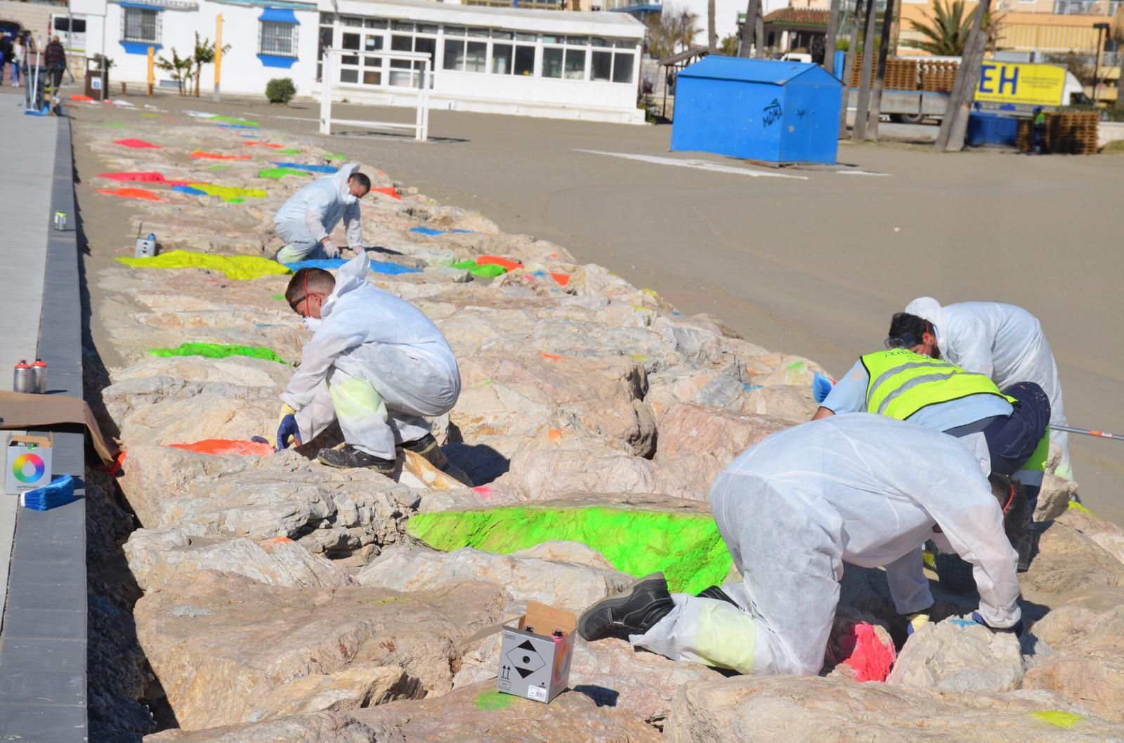 Varias personas pintan el espigón
