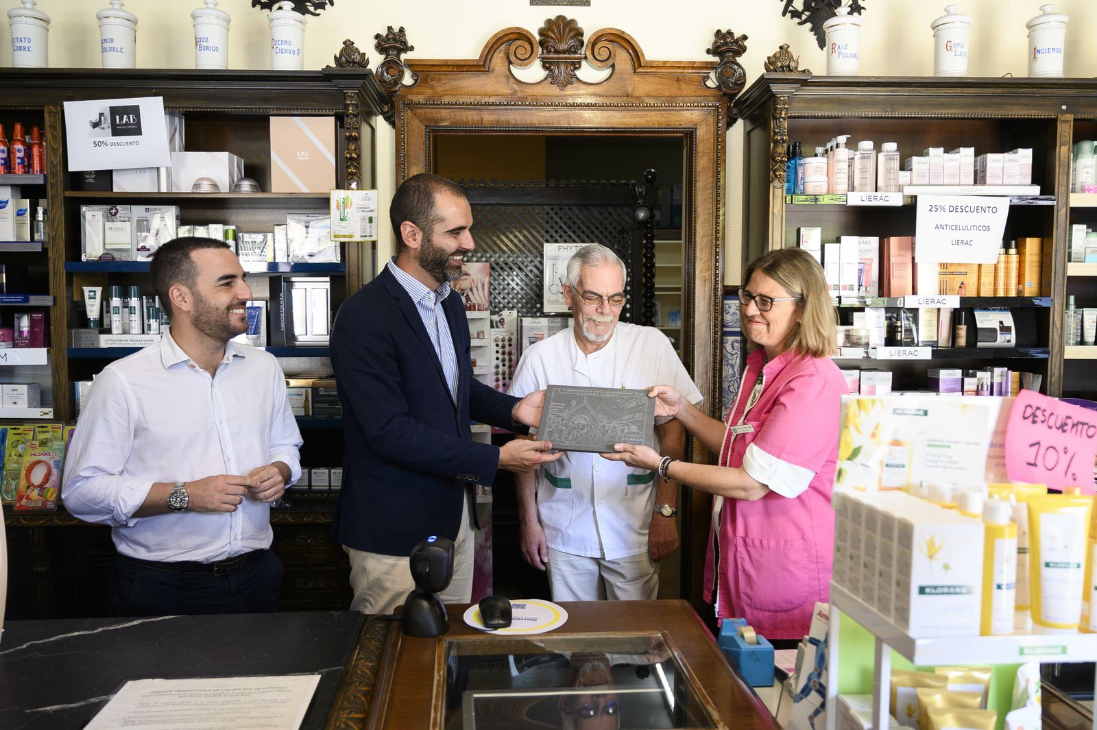El alcalde hace entrega de la placa de establecimiento histórico a la farmacéutica María del Mar López