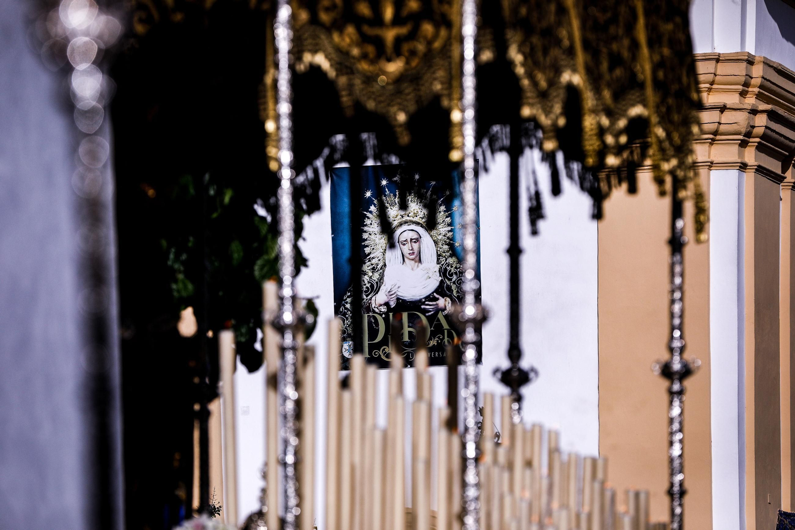 Cartel del aniversario de la Piedad, entrevisto entre los varales de su paso de palio el pasado Jueves Santo en San Fernando