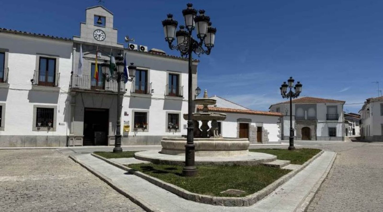 Ayuntamiento de Torrecampo, con la fuente de piedra delante.